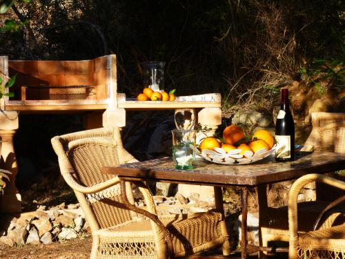 un tavolo con una ciotola di frutta e una bottiglia di vino di Finca Almendra a Cala Mesquida