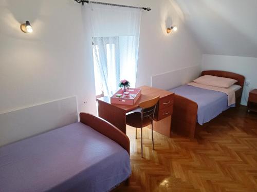 a room with two beds and a desk and a window at Apartments F&A in Split
