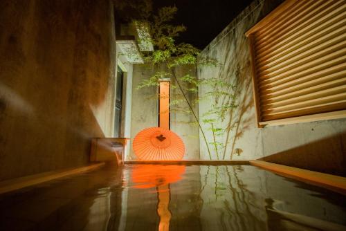 an orange umbrella sitting on the side of a building at Kamei no Yu in Yamanouchi