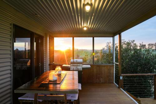 a wooden deck with a table and a laptop on it at Six-Ten Shores in Dolphin Sands