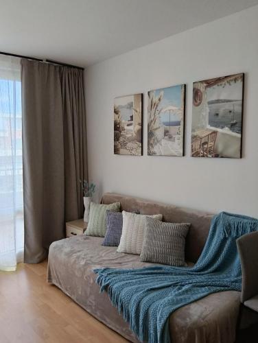 a couch in a living room with pictures on the wall at Sea Breeze Studio at Fort Noks Resort in Sunny Beach
