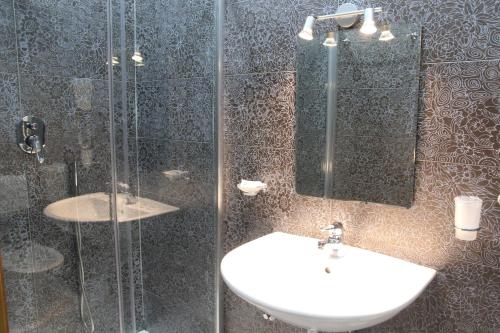 a bathroom with a sink and a glass shower at Hotel Luna Rossa in Naples