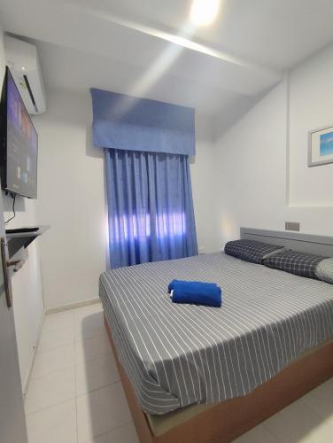a bedroom with a bed with a blue pillow on it at Paraiso La Mata in La Mata