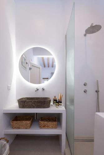 a bathroom with a sink and a mirror at Aurum Suites Sifnos in Kamares