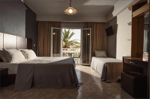 a hotel room with two beds and a balcony at Zante Calinica Hotel in Tsilivi