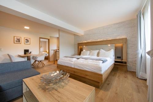 a bedroom with a large bed and a living room at Appartementhaus EifelAdventures in Berlingen