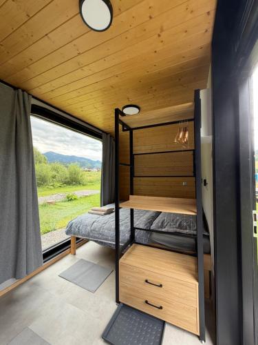a bedroom in a tiny house with a window at Tatry Panorama House in Zuberec