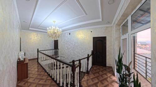 a room with a staircase and a chandelier at ESAL House in Karakol