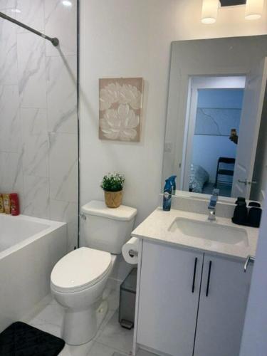 a bathroom with a toilet and a sink and a shower at Modern Rangeview Stay Near YMCA & Cineplex Cinema in Calgary
