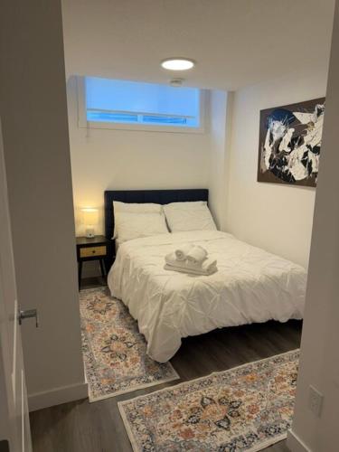 a bedroom with a bed with a hat on it at Modern Rangeview Stay Near YMCA & Cineplex Cinema in Calgary