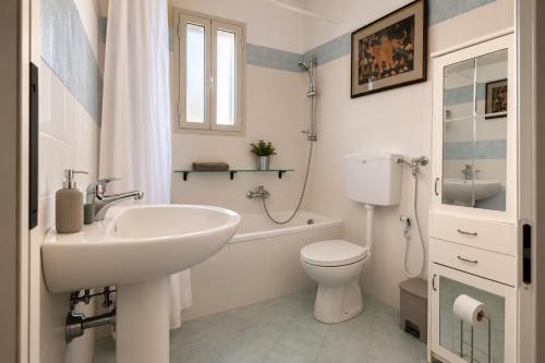 a white bathroom with a sink and a toilet at Casa del Carrubo con Piscina, relax in campagna vicino al mare in Santa Croce Camerina