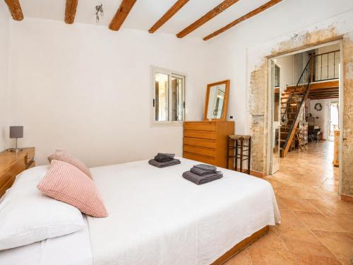 a white bedroom with a bed and a staircase at Casa del Carrubo con Piscina, relax in campagna vicino al mare in Santa Croce Camerina