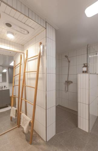 a bathroom with white tiled walls and a shower at 스테이 모슬 in Daejeong