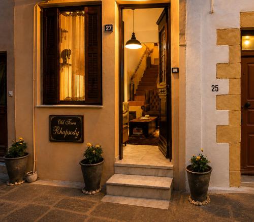 a entrance to a building with two potted plants at Old Town Rhapsody, Cosy 2-Floor Home with Rooftop Bathtub, BBQ & Lounge Under Sun Umbrellas in Rethymno