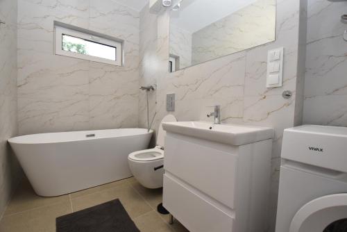 a white bathroom with a toilet and a sink at Turawski Zakątek in Turawa