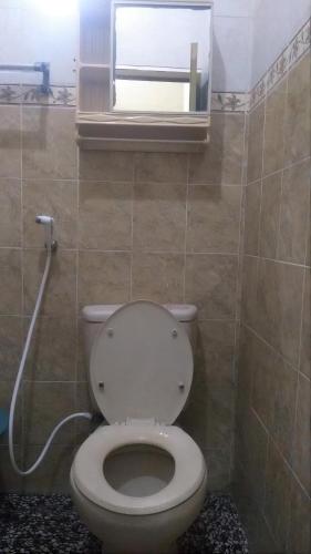 a bathroom with a toilet and a window at Ambarosed Homestay in Ngaglik