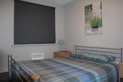 um quarto com uma cama e um quadro na parede em Mirage em Ostend