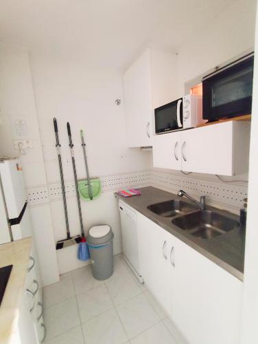 a small kitchen with a sink and a microwave at Paraiso La Mata in La Mata