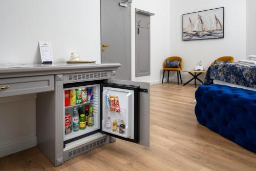 a refrigerator in a living room next to a blue couch at Boutique Hotel Golden Key - Poreč - Bed & Breakfast in Poreč