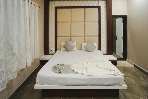 a bedroom with a large bed with white sheets and pillows at K2 Highway Treat & Resort Unit of Lyzon in Bhadaura