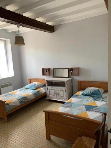 a bedroom with two beds and a mirror at Au lic in Montsoué