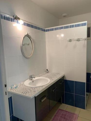 a bathroom with a sink and a mirror at Au lic in Montsoué