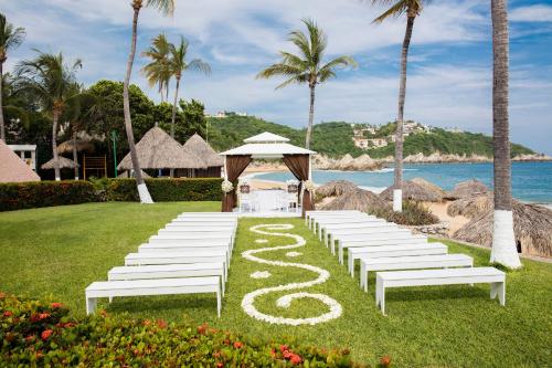 a wedding aisle with white benches and a gazebo at Barceló Huatulco - All Inclusive in Santa Cruz Huatulco