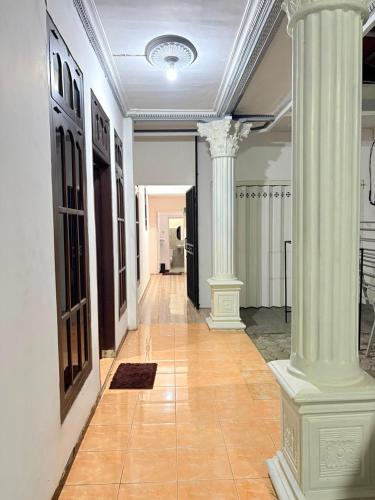 a hallway with two white columns in a building at Homestay Anugerah Tumpak sewu in Lumajang