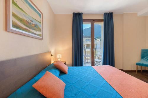 a bedroom with a blue bed and a window at Foresteria BB Sul Lago in Porlezza