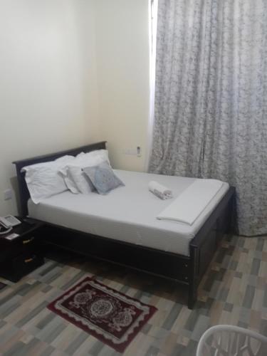 a small bed in a room with a window at Nelca Executive Lodge in Mwanza