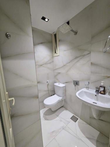 a white bathroom with a toilet and a sink at Luxury Studio in 6october in 6th Of October