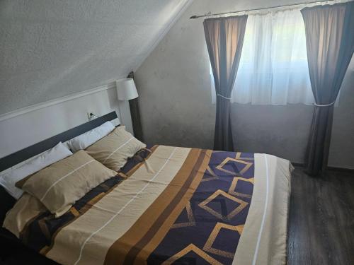 a bedroom with a bed and a window at Vikend house Cvrcak in Slankamenački Vinogradi
