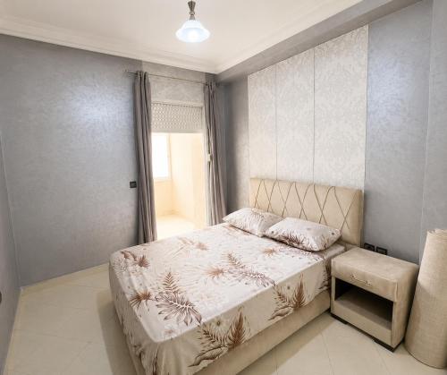 a bedroom with a bed and a window at Stylish and valm appartement in Kenitra