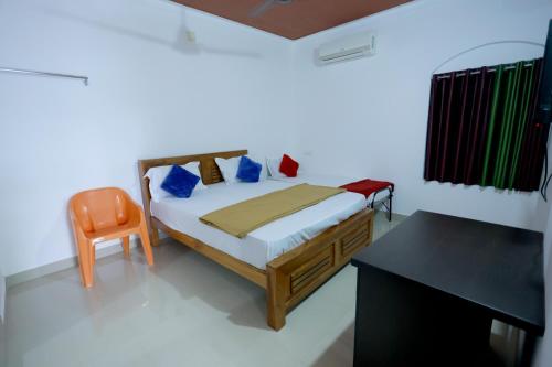 a bedroom with a bed and a desk at Nirmalyam Homestay in Kuttippuram