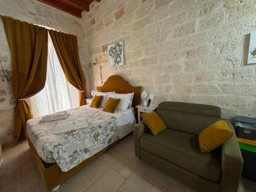 a bedroom with a bed and a chair at Casa Nave in Monopoli