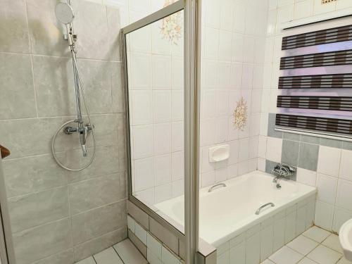 a bathroom with a shower and a tub and a sink at Ave Maria Camping site in Welkom