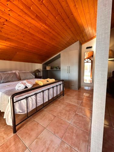 a large bed in a room with a wooden ceiling at Tproject in Preveza