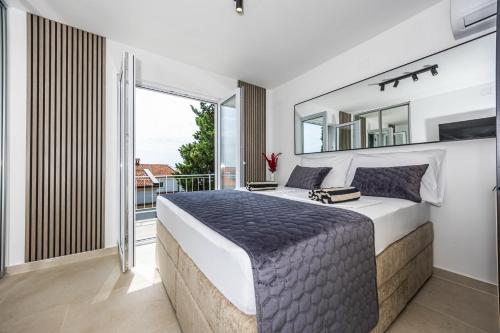 a bedroom with a large bed and a balcony at Korina Suites - 2 appartments, 1 with jacuzzy in Dramalj