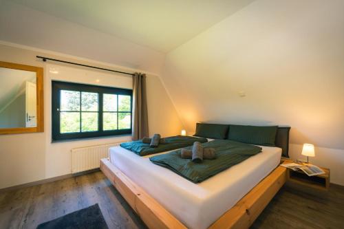 a bedroom with a large bed and a window at Reetdachhaus Laurin in Dranske in Dranske