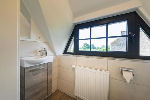 a bathroom with a sink and a window at Reetdachhaus Laurin in Dranske in Dranske