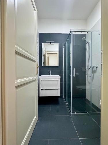 a bathroom with a glass shower and a sink at Perlová Suites in Pilsen