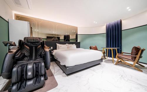 a hotel room with a bed and a chair at 호텔 어게인 in Cheongju