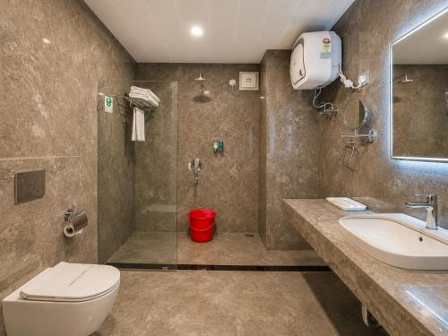 a bathroom with a toilet and a shower and a sink at Lotus Villa in Phuntsholing