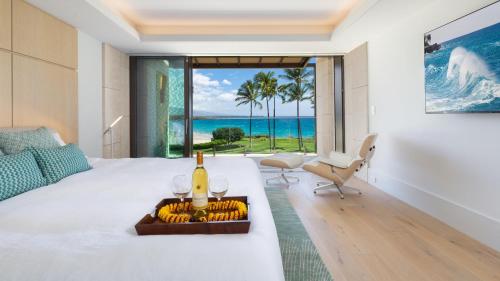 a bedroom with a bed with a bottle of wine on it at ❤PiH❤ Hapuna Surfside Beachfront Steps From Ocean B26 in Hapuna Beach