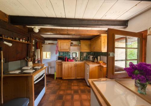 a large kitchen with wooden cabinets and a window at Chalet 1813 Nature & Panorama in Montreux