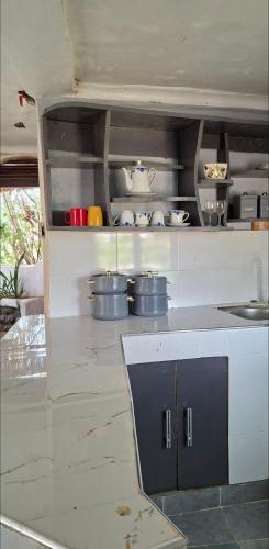 a kitchen with a counter with pots and pans at Nchaman Nest in Loiyangalani 