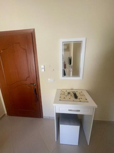 a bathroom with a white table and a mirror at Honey Residence in Sarandë