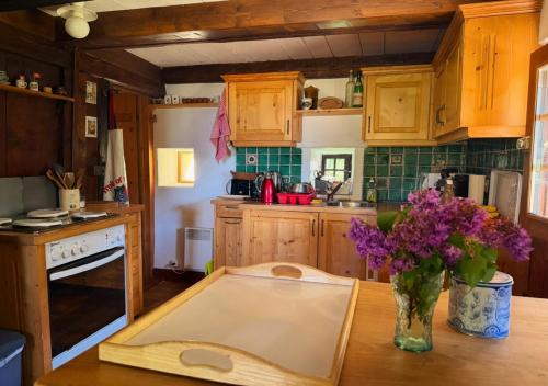 a kitchen with wooden cabinets and a vase of flowers on a table at Chalet 1813 Nature & Panorama in Montreux