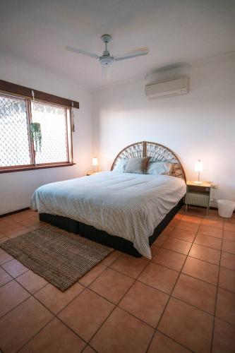 a bedroom with a bed and two lamps on a tiled floor at Dune Break in Exmouth