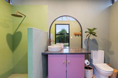 a bathroom with a sink and a mirror and a toilet at Dune Break in Exmouth